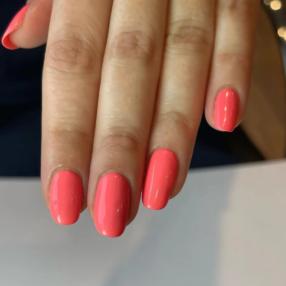 DND Daisy Gel Duo Coral Reef #556 featuring vibrant coral gel nail polish and lacquer swatch on a nail tip.