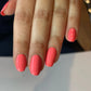DND Daisy Gel Duo Coral Reef #556 featuring vibrant coral gel nail polish and lacquer swatch on a nail tip.