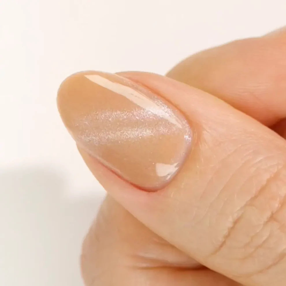 DND DC Gel Polish in Caramel Lullaby, a nude cream shade with velvet cat-eye shimmer, shown as a swatch on nails.
