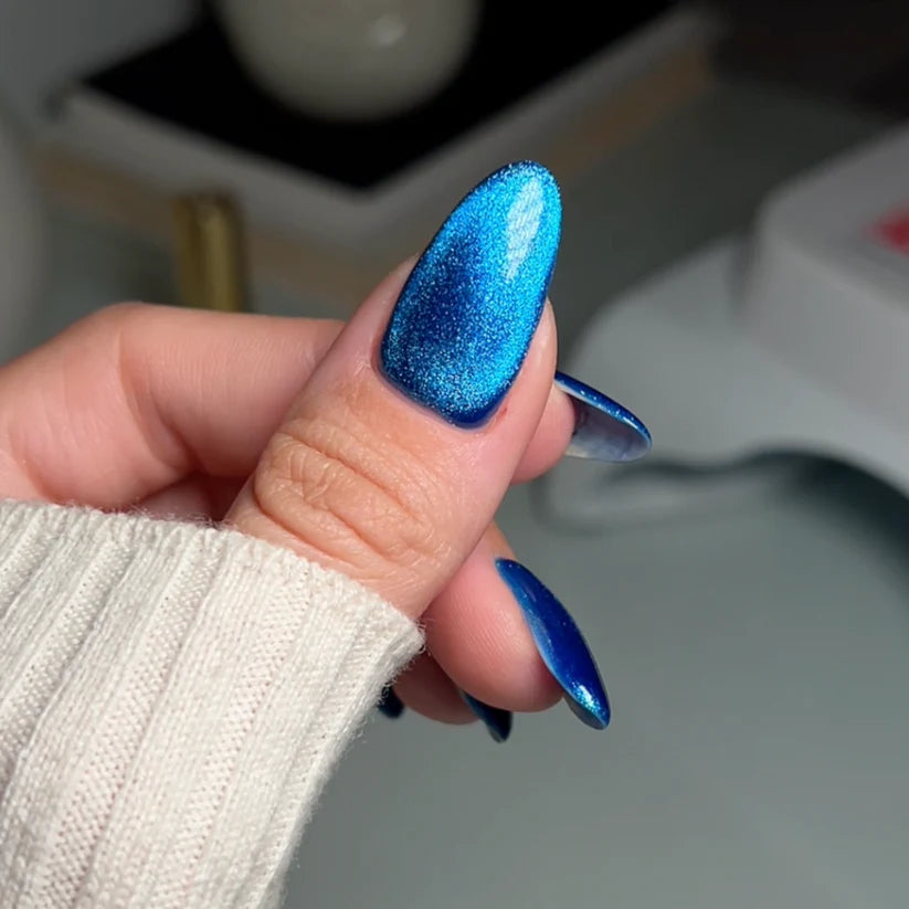 DND DC Gel Cat Eye polish in Galactic Sapphire #04, showcasing smooth gel nail color with a shimmering blue cat eye effect.