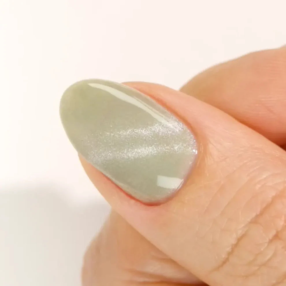 DND DC Gel Cat Eye polish in Misty Moss, a soft green with velvet shimmer and cat eye effect on nail swatch.