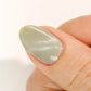 DND DC Gel Cat Eye polish in Misty Moss, a soft green with velvet shimmer and cat eye effect on nail swatch.