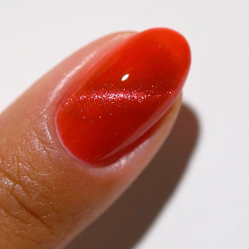 DND DC Gel Polish in Ruby Mirage #03 with a vibrant, glossy cat eye effect, showcasing deep red and shimmering accents.