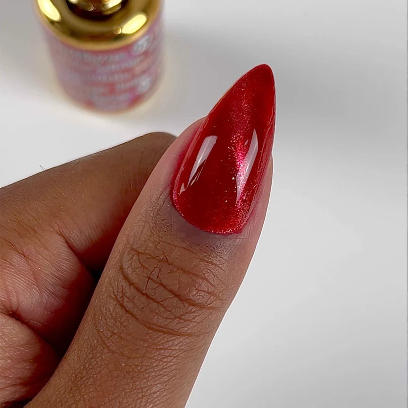 DND DC Gel Polish in Ruby Mirage #03, vibrant red cat eye gel nail polish with shimmering effect, shown on a nail.