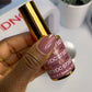 Swatch of DND DC Gel Duo Dusty Red #073 gel nail polish and lacquer, showing glossy, vibrant red color on nail tip.