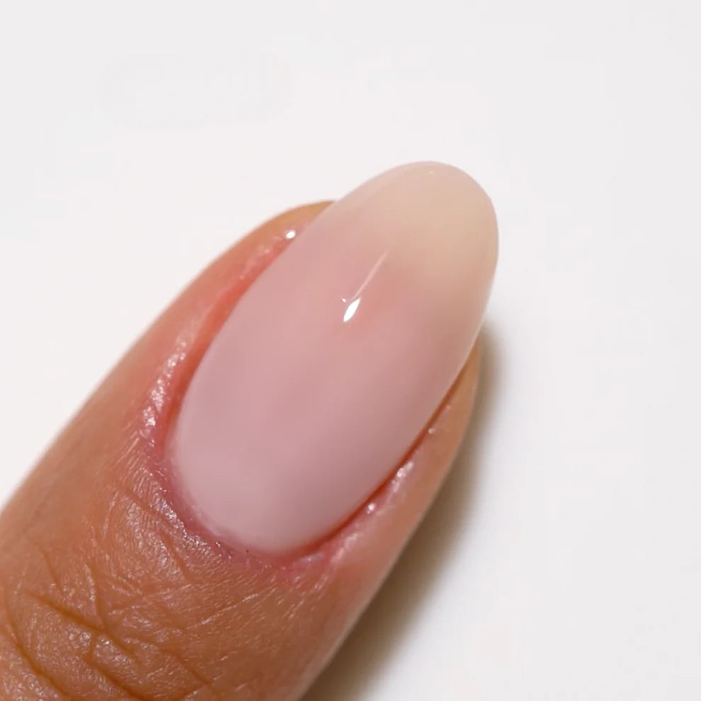 Swatch of DND DC Gel Duo Milky Pink #2461 gel nail polish and lacquer in a soft pink shade on a white background.