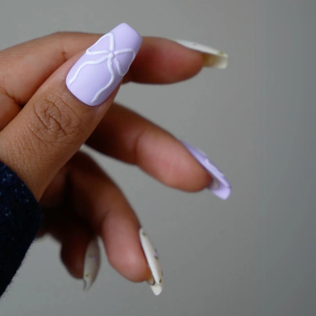 DND Diva Duo Gel & Polish in Dainty Lavender 103, featuring a pastel lavender gel nail polish and lacquer with a white nail art design.