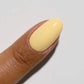 Swatch of DND Diva Duo Gel & Polish in Dandelion 084, showing vibrant yellow gel nail polish and lacquer finish.
