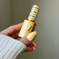 Swatch of DND Diva Duo Gel & Polish in Dandelion 084 showing bright yellow gel nail polish and lacquer finish.