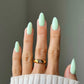 Swatch of DND Diva Duo Gel & Polish in Peppermint Marshmallow 104, showing a glossy mint green gel nail polish and lacquer.