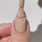 Swatch of DND Diva Duo Gel & Polish in Toasted 051 showing a warm nude gel nail polish and lacquer finish.