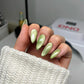 DND Diva 9D Cat Eye Gel Polish in Leafy Prowl, featuring a shimmering green and gold glassball finish on a nail tip.