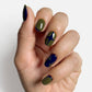 Essie Meet Me At Midnight #1797 nail lacquer in a dark, shimmering blue shade, displayed with a step-out nail art look.
