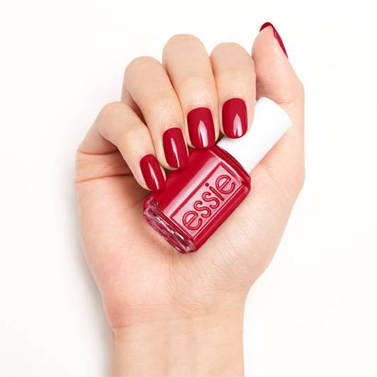 Essie nail lacquer in Not Red-y for Bed #490, showcasing the vibrant red color on a hand with neatly manicured nails.