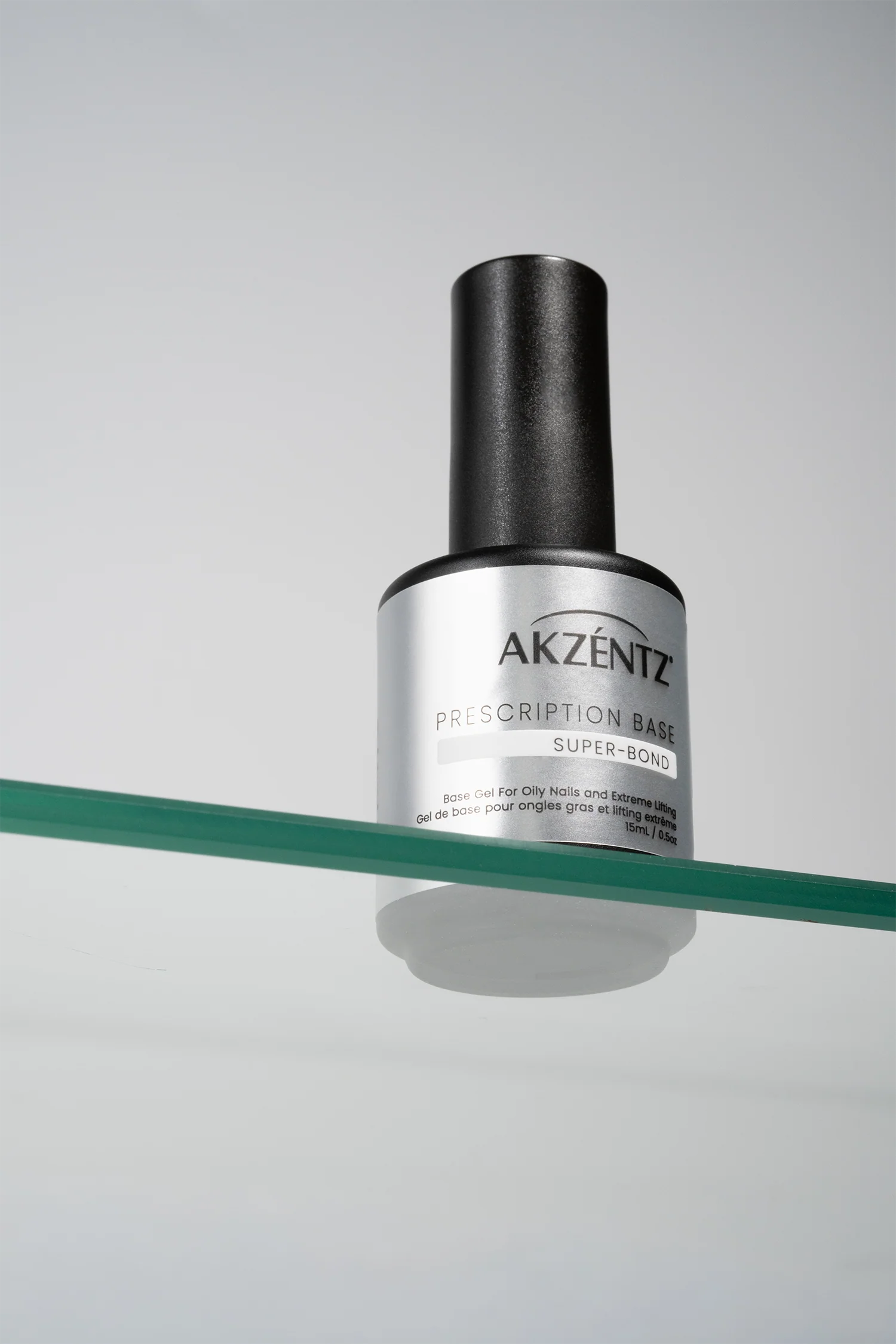Luxio Prescription Soak Off Base™ gel for Luxio gel polish, shown in a clear bottle with applicator brush for super-bond adhesion.