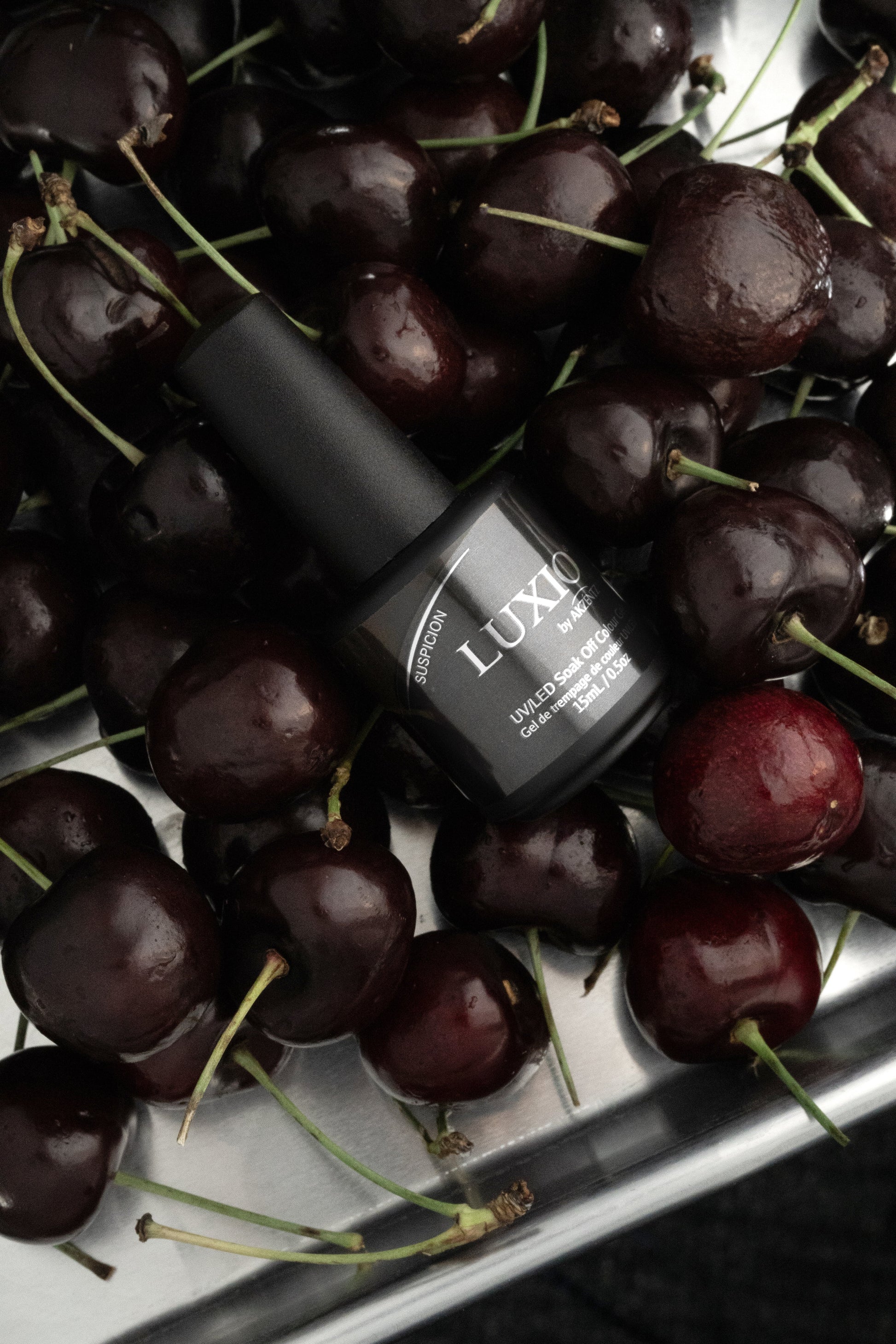 Luxio Soak-Off Gel Polish in Suspicion 15ml bottle, showcasing the deep, rich gel color with a smooth, glossy finish.