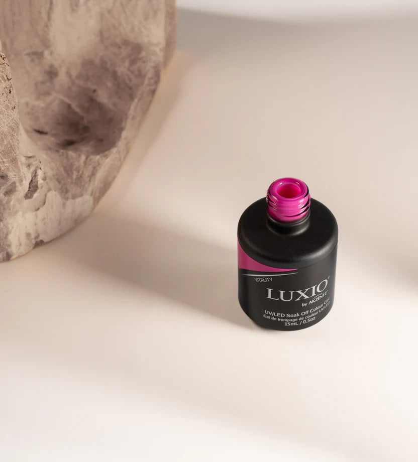 Open bottle of Luxio Soak-Off Gel Polish Vitality 15ml, showcasing the bright pink gel inside.