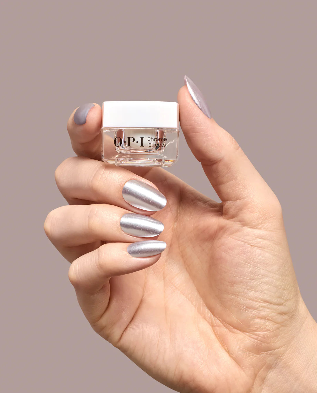 OPI Chrome Powder Chrome to Mama applied on nails, showing a shiny metallic finish, with bottle of OPI Chrome Powder in the background.