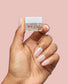 OPI Chrome Powder Tin Man Can Glaze over nail with baby take a vow color, showcasing metallic powder nail polish in bottle and hand.