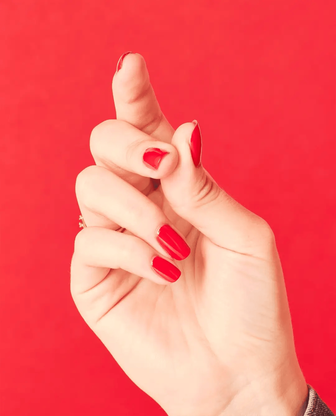 OPI Nail Polish in Cajun Shrimp shade, vibrant coral-orange color, with a glossy finish on a nail display.