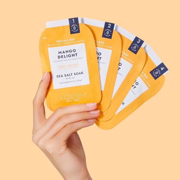 Voesh Pedi In A Box Mango Delight 4 Step kit with foot care products, featuring vibrant mango-themed packaging and foot soak items.